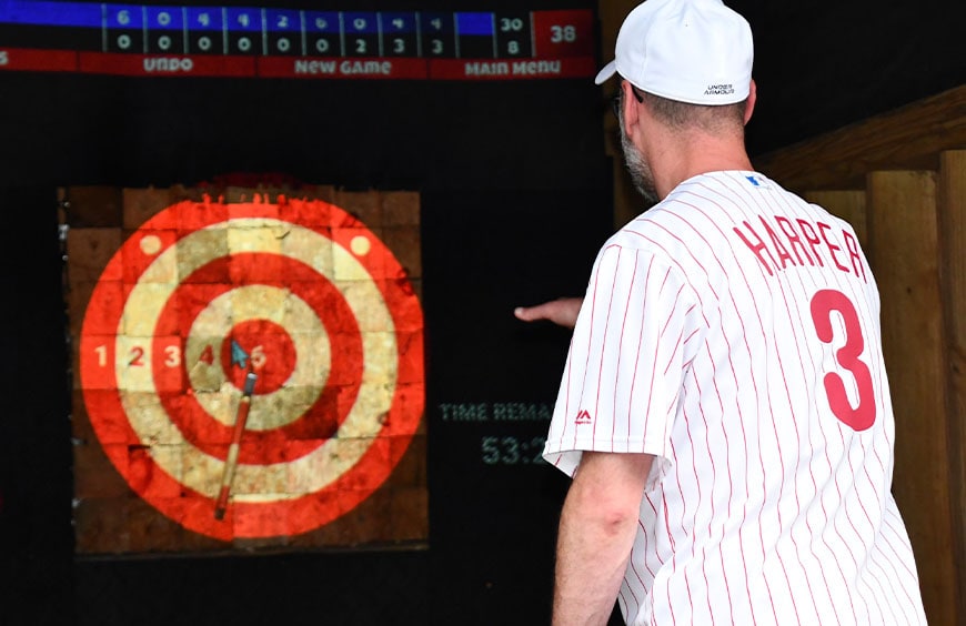 Throwing a bullseye at an outdoor axe throwing party at The Adventure Park at Sandy Spring
